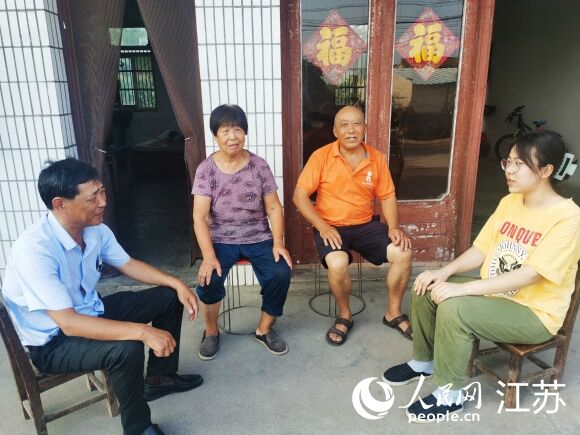 街道民政助理蒋新（左一）到明圣楠家里走访。人民网记者王继亮摄