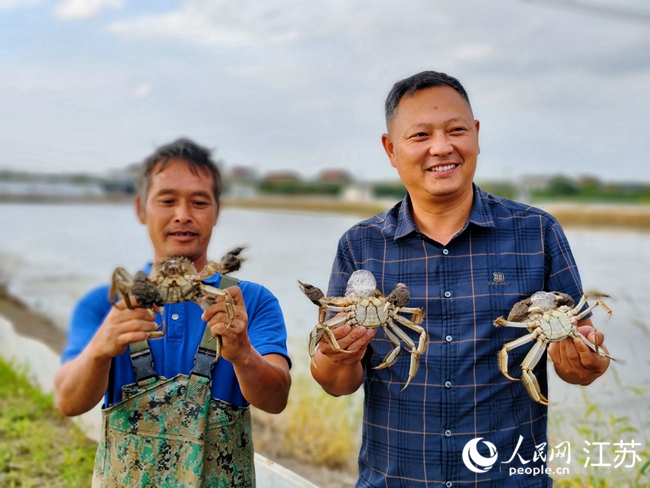 致富带头人王光玉（右）展示养殖的大闸蟹。人民网记者 王继亮摄